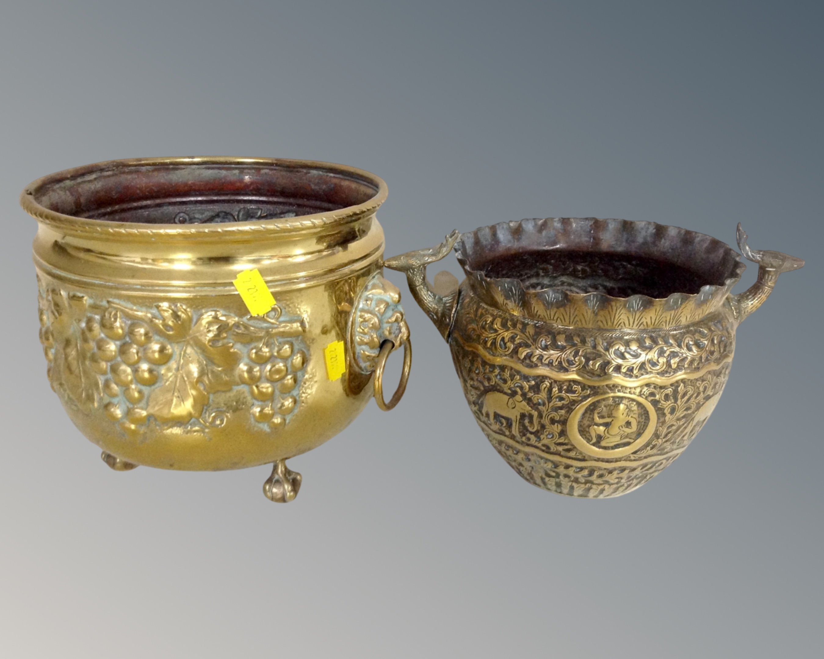 An Indian brass deer head-handled planter together with a further antique brass embossed planter