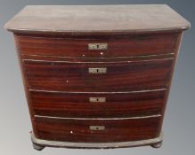 A 19th century stained pine bow fronted four drawer chest on bun feet.