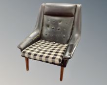 A mid-20th century Scandinavian armchair upholstered in black vinyl on teak legs.