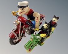 Two cast iron figures on motorbikes, Mickey Mouse and Popeye.