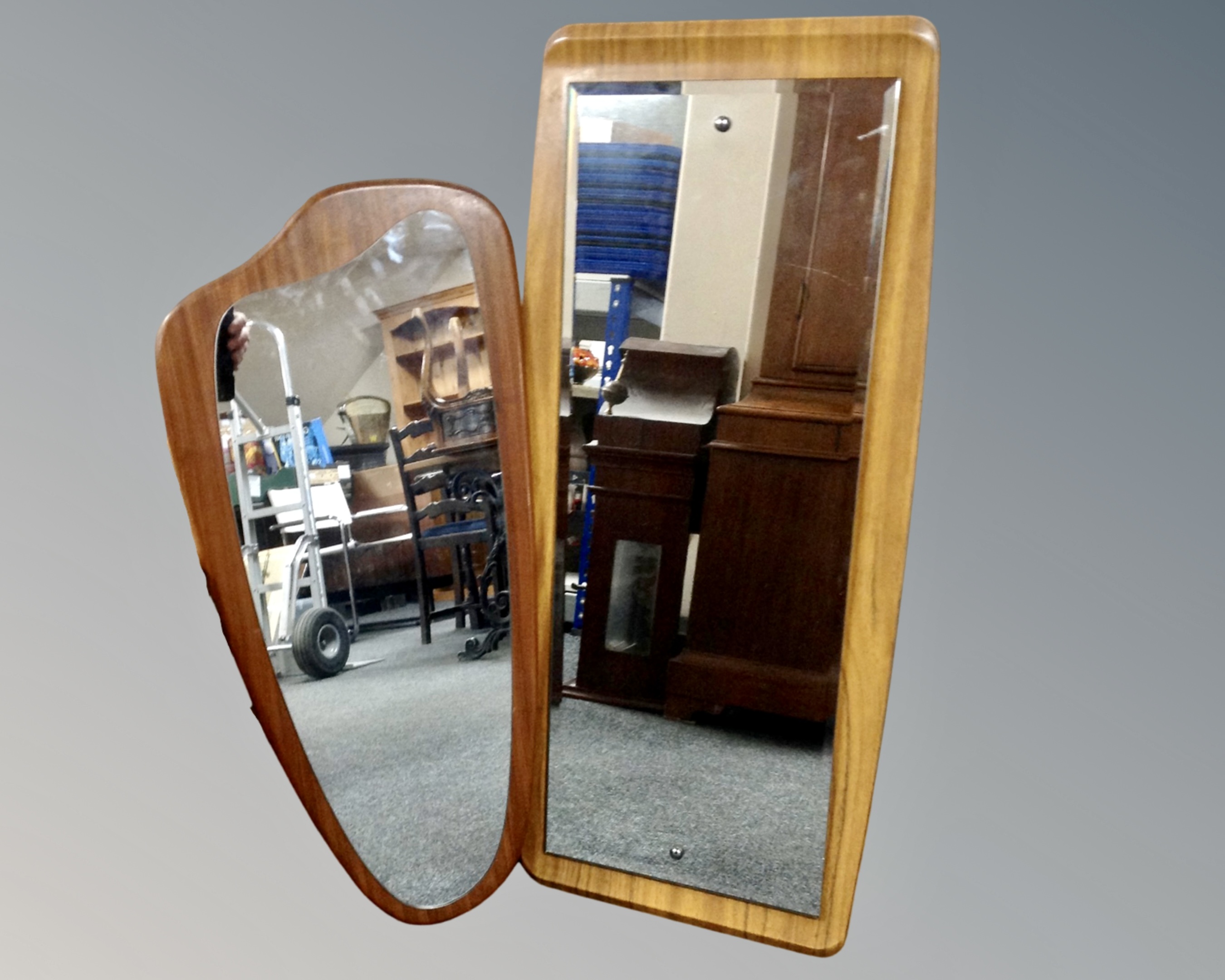 A mid-century frameless mirror mounted on a teak board together with a further formwood mirror.