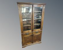 An Edwardian oak glazed double door bookcase fitted with cupboards and drawers beneath.