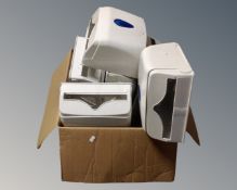 A box containing a quantity of plastic paper towel dispensers.