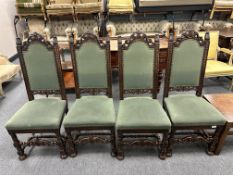 A set of four carved oak high backed dining chairs.