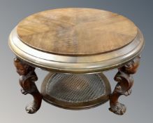 A continental oval beech two tier occasional table with bergere shelf on carved cherub legs.