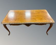 A 20th century walnut coffee table on cabriole legs.