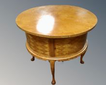 A 20th century French walnut circular drum table on raised legs.