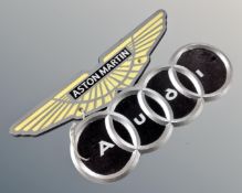 Two cast iron plaques, Aston Martin and Audi.
