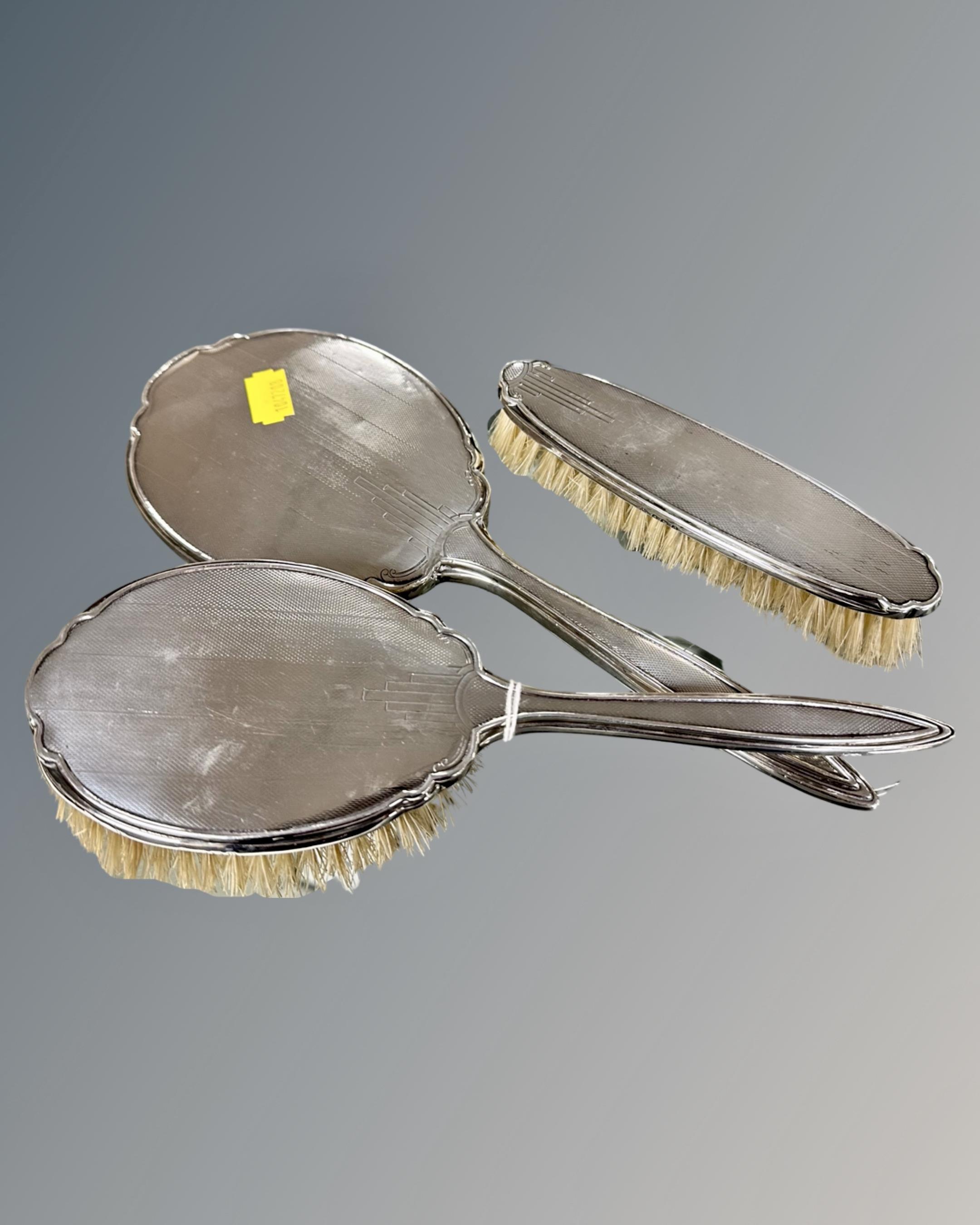 A three piece 1940s Sheffield silver brush and hand mirror set.