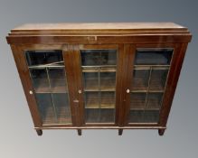 A 20th century mahogany triple door bookcase with leaded glass doors, height 118 cm, width 144 cm,