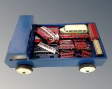 A vintage wooden flatbed truck containing play-worn die cast busses.