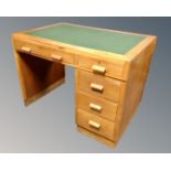 A mid-20th century oak single pedestal desk fitted with a green leather inset panel and five
