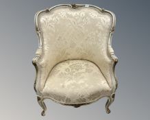 A French Louis XV style cream and gilt armchair.