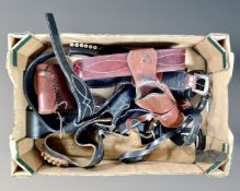 A box containing tooled leather gun belts and holsters.