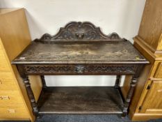 A 19th century heavily carved oak console table fitted with a drawer.