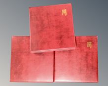 Three red leather postcard albums with inserts.