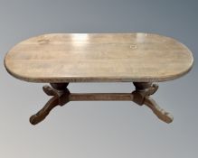 A solid oak oval refectory dining table.