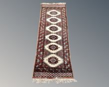 A Bokhara style fringed runner.