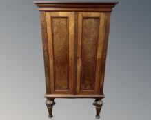 A 19th century continental mahogany and walnut double door cabinet on raised legs.