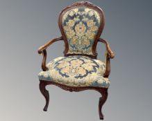 A French beech framed salon armchair upholstered in a floral brocade.