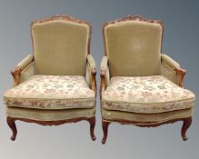 A pair of French carved beech low armchairs upholstered in a green fabric.