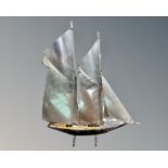 A wood and chrome model of a sailboat.