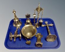 A tray of brass ware, opium spoon, miniature companion set on stand, crucifixes, hand bells,