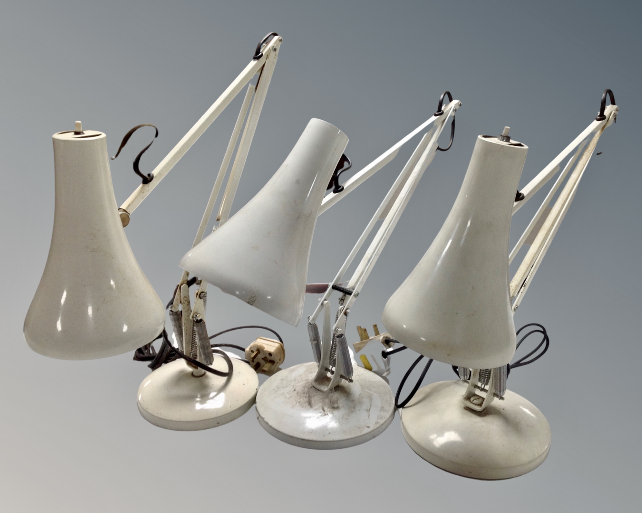 Three white metal angle poise lamps