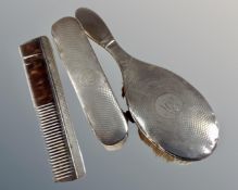 A three piece silver backed dressing table brush and comb set