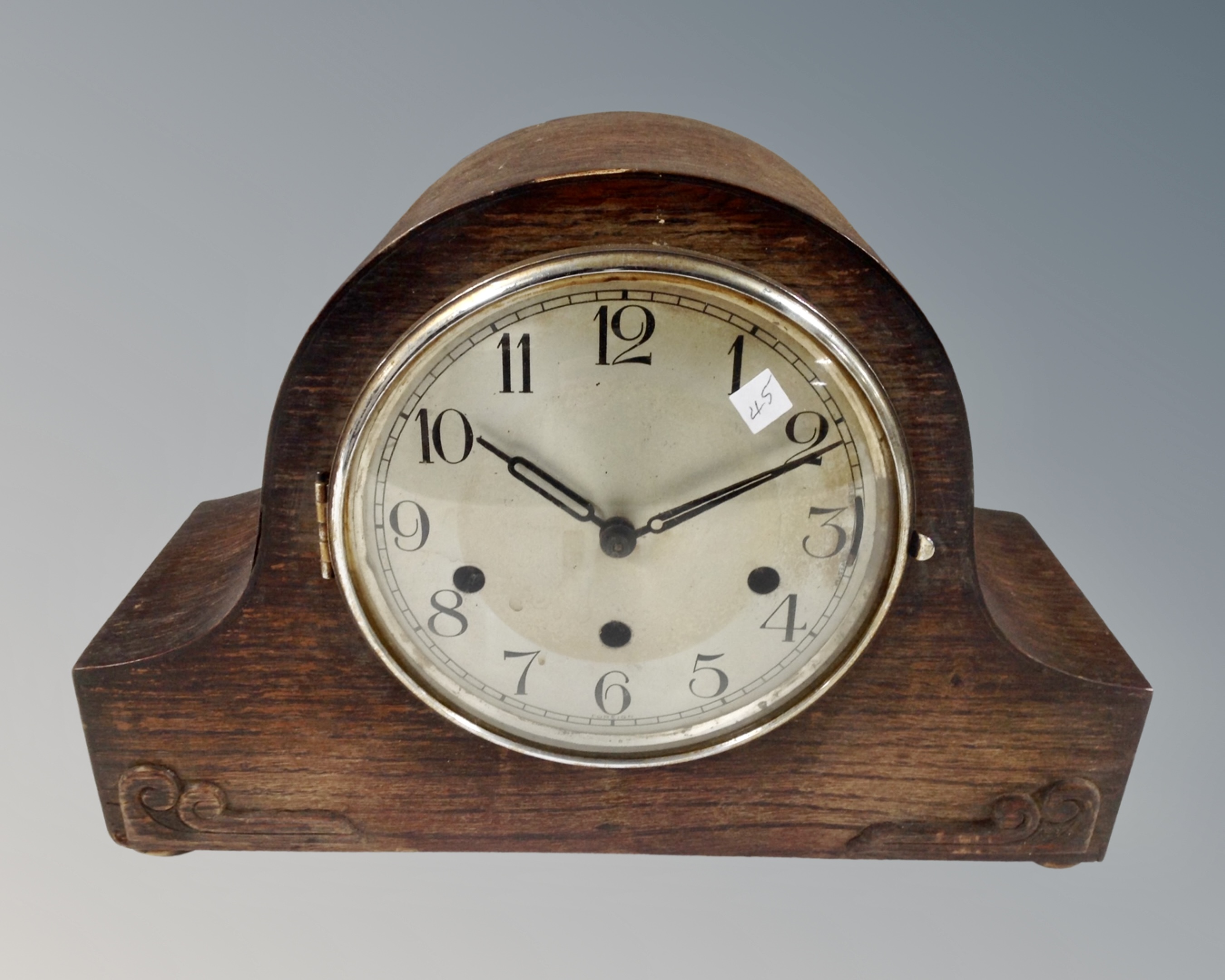 A 1930s oak cased mantel clock with silvered dial