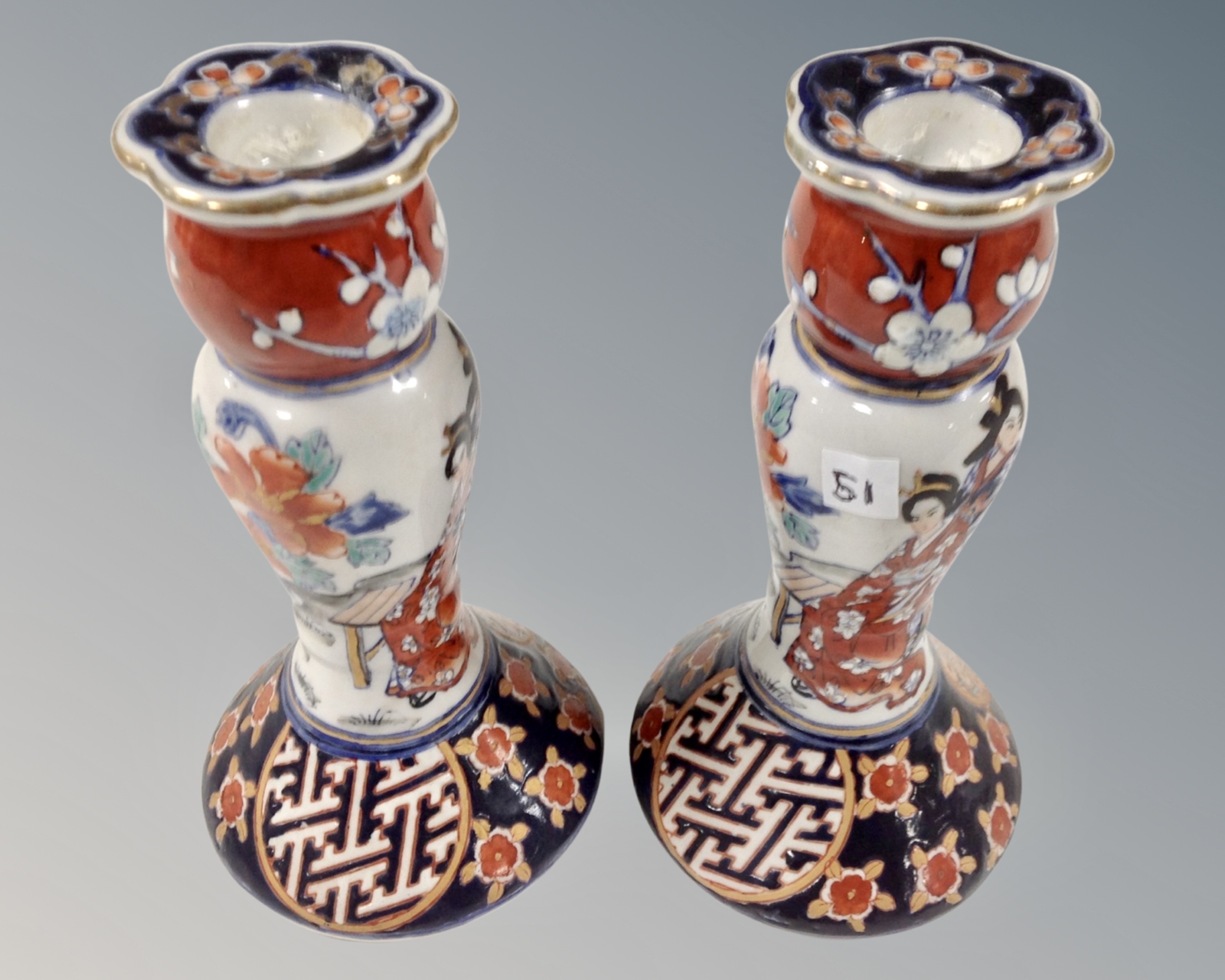 A pair of Japanese ceramic candlesticks depicting Geisha, height 16 cm.