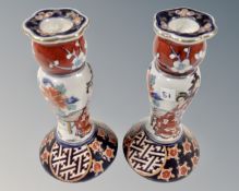 A pair of Japanese ceramic candlesticks depicting Geisha, height 16 cm.