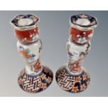 A pair of Japanese ceramic candlesticks depicting Geisha, height 16 cm.