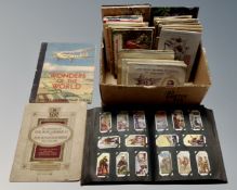 A box of cigarette and tea cards in albums