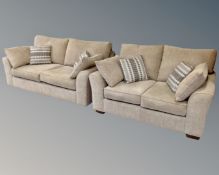 A three seater and two seater settee upholstered in beige fabric with loose scatter cushions