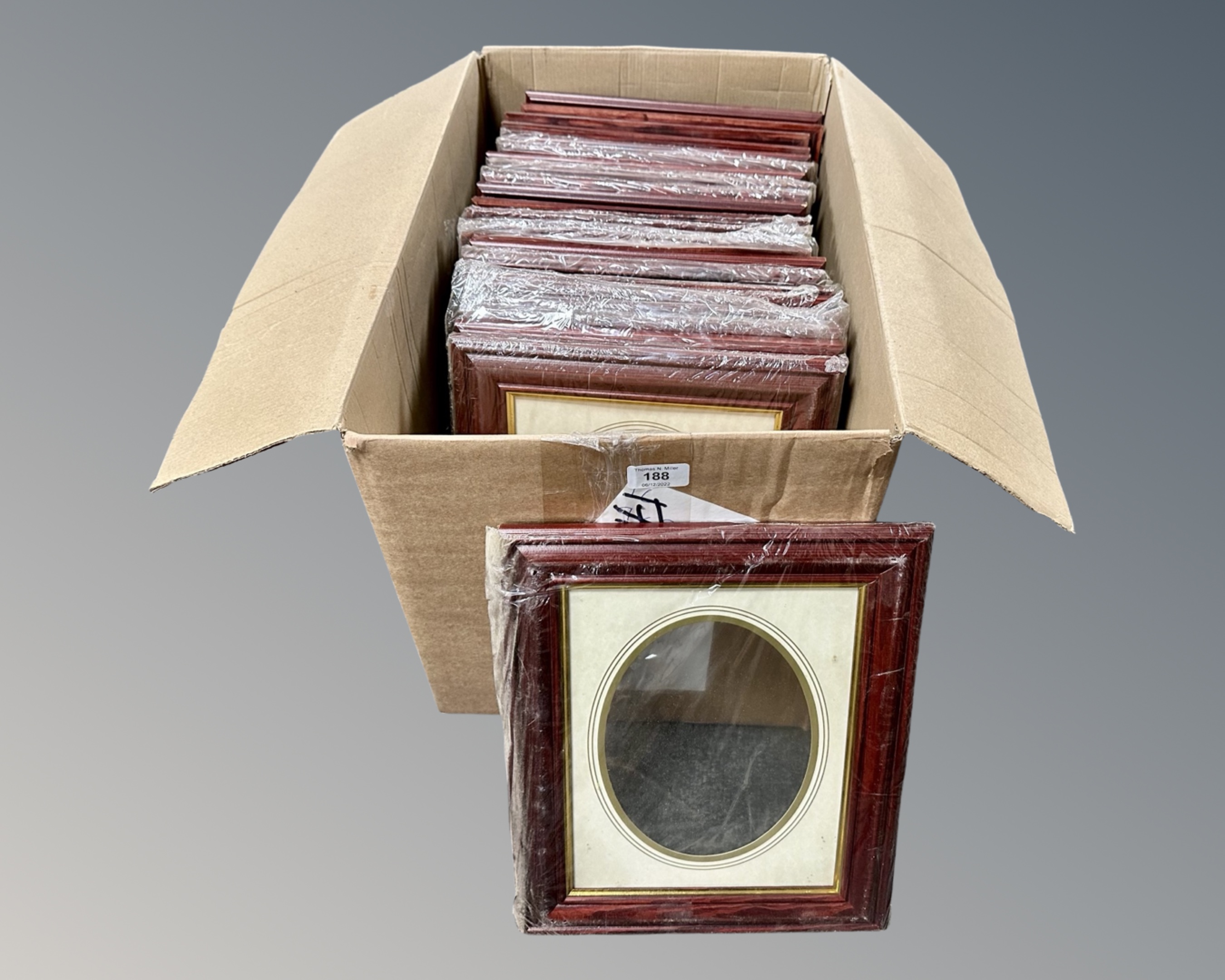 One crate containing twenty three dark wood photo frames, 20 cm x 25 cm,