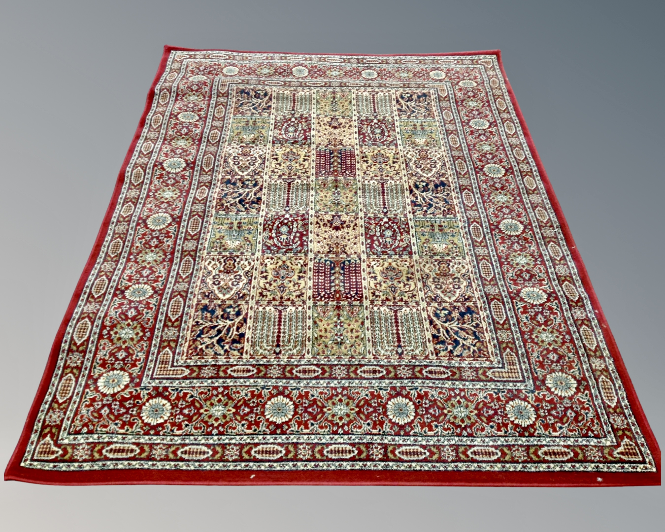 A machine made Persian design carpet on red ground,