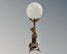 A gilt metal and black marble figural table lamp with opaque ball glass shade (base as found)