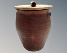A vintage earthen ware pot with wooden lid