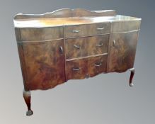 A 1930s mahogany shaped front sideboard fitted three central drawers