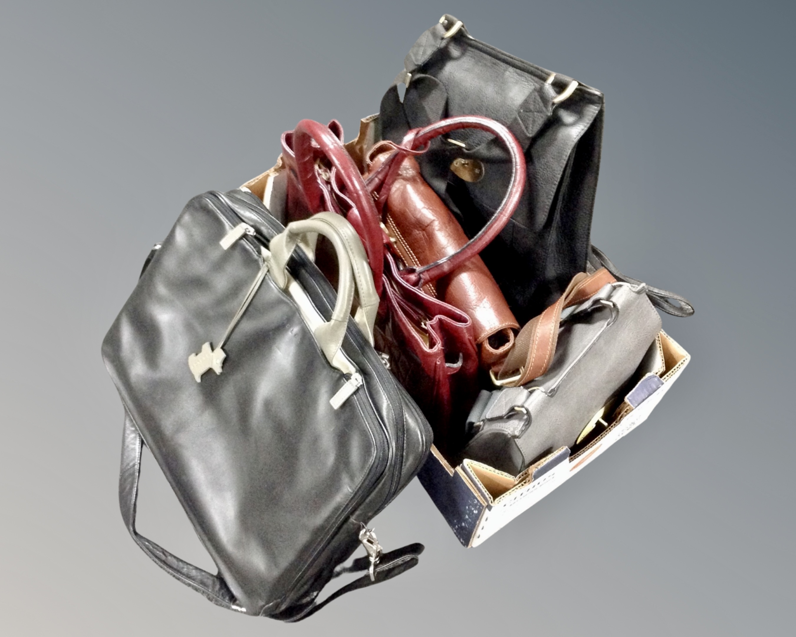 A box of four leather handbags together with a Radley lap top bag
