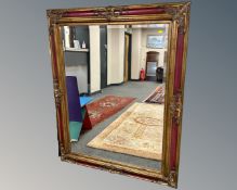A contemporary red and gilt mirror,