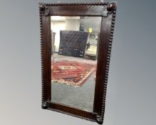 An Edwardian beaded oak framed mirror