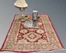 A Persian designed machine made rug together with two contemporary table lamps and metal framed