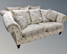 A pair of scroll arm two seater settees in beige fabric