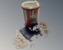 A box containing a vintage tin, medals and badges, a costume pearl necklace, gilt pendant etc.
