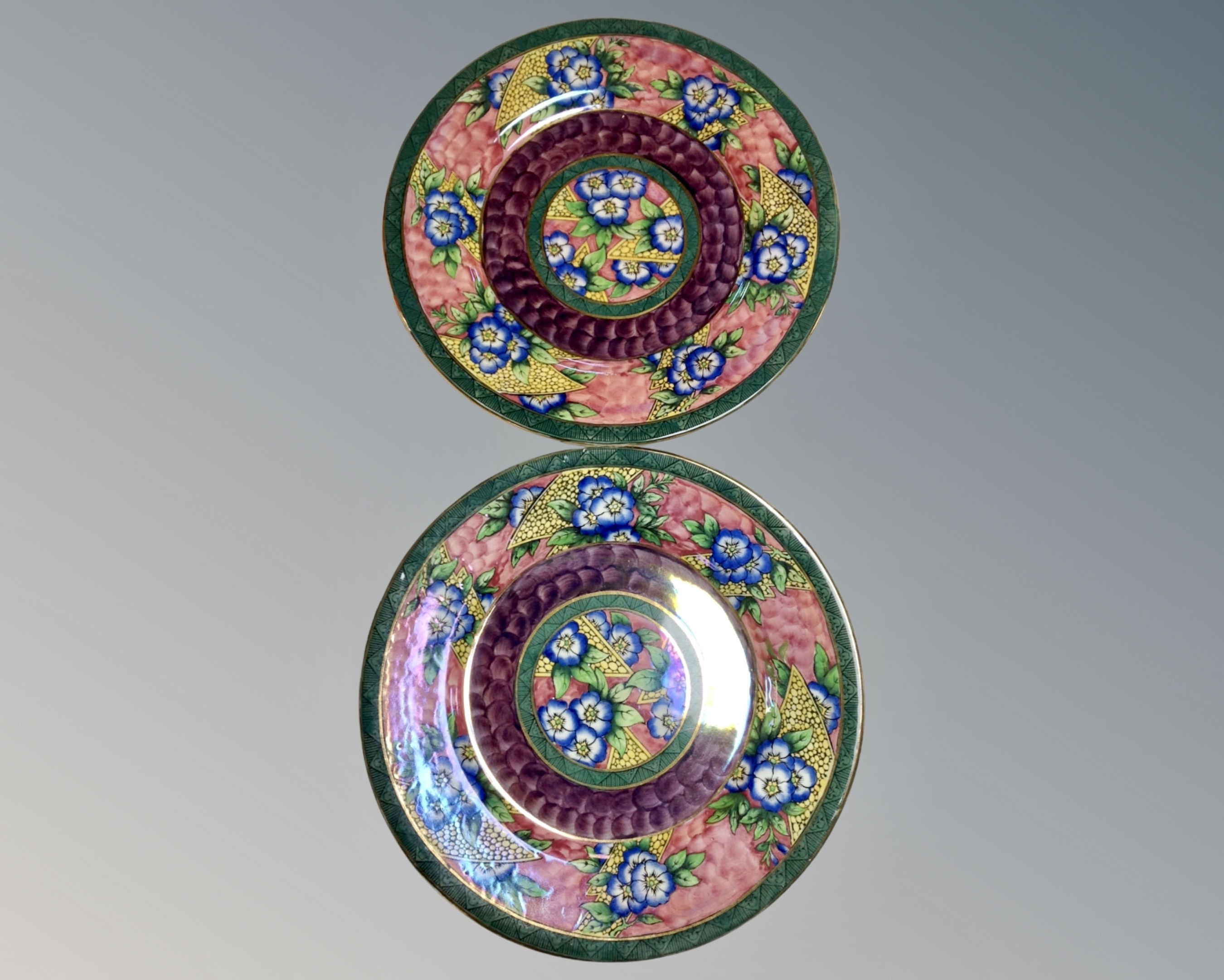 A pair of Maling lustre plates on pink and green ground.