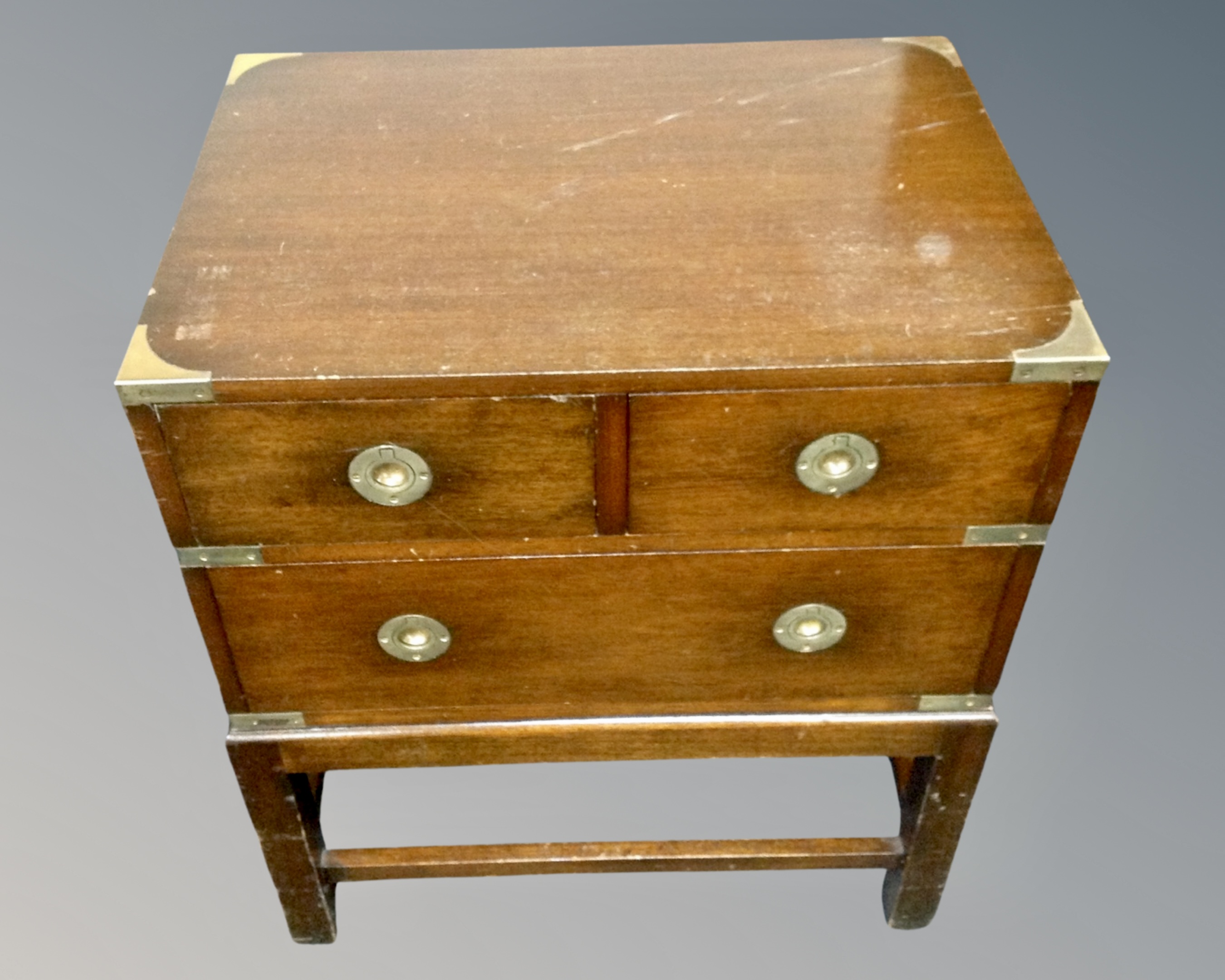 A mahogany ship's style two-over-one three drawer chest on raised legs with brass mounts.
