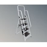 A four-tread folding step ladder with double hand rail
