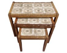 A nest of three mid-20th century teak tile topped tables.